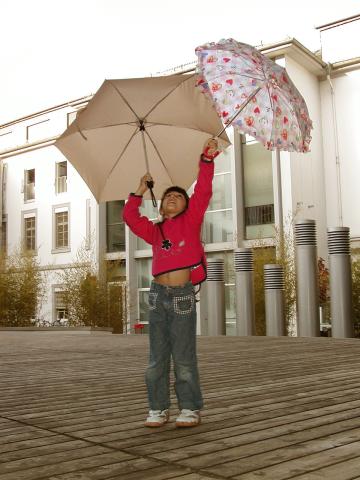 Xandie dodging raindrops in the International Department courtyard.