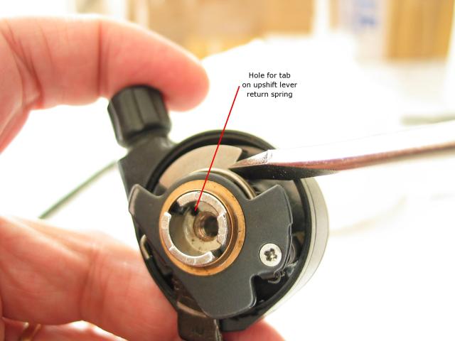 Using a flat-bladed screwdriver, rotate the shift cam counterclockwise
as far as possible to make room for installing the upshift pawl.