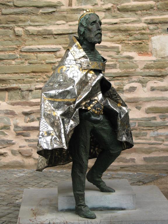 A statue of Charlemagne, complete with crown and cloth mantle at the Aachen cathedral.