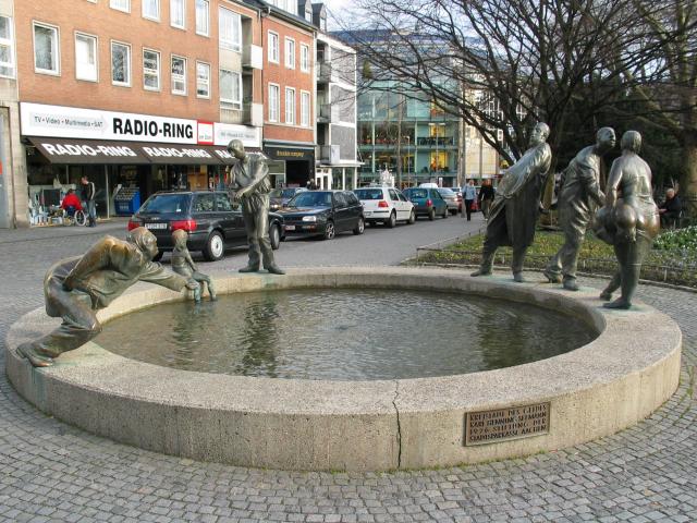 The "Puppenbrunnen", or Doll Fountain, in Aachen, with ordinary people in comical poses.