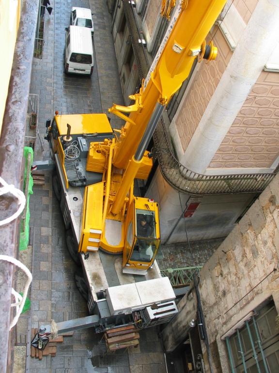 The mobile crane that was set up outside our hotel room in Girona. The placement of this crane is a masterpiece of positioning: when it swings counterclockwise it clears the buildings on the left by about 6 inches, and the main boom can then lift things into the narrow alley on the right.  If you look closely, you can see green cantilever lying on the ground of that alley; this is part of the stork crane that the mobile crane was erecting atop the building to the upper right of the photograph.