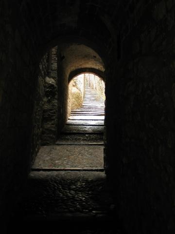 A Moorish-influenced passageway leads to sunlight in Girona.