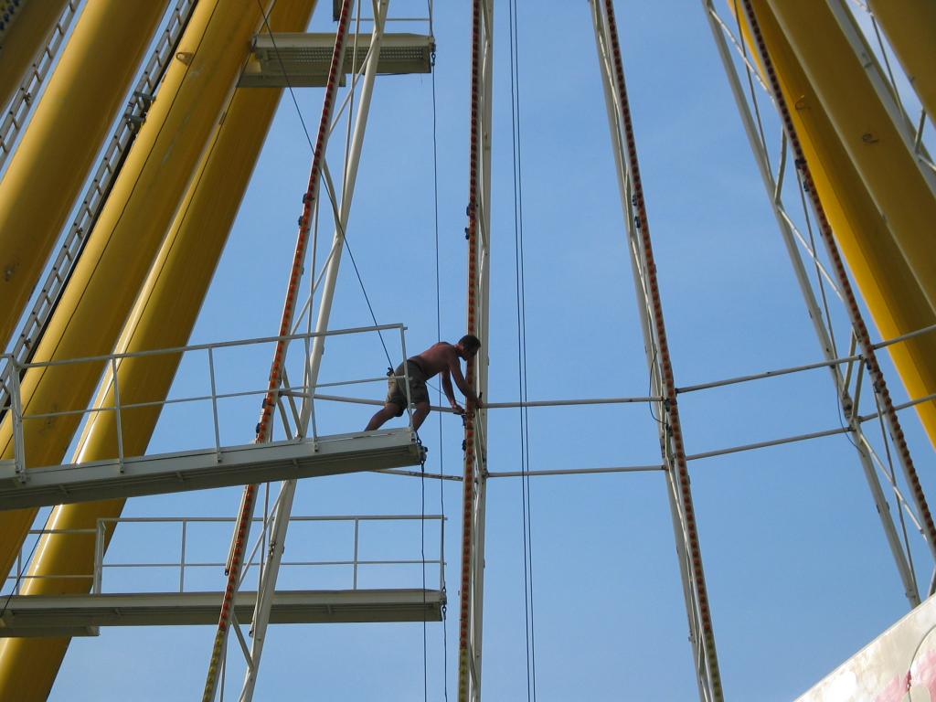 Disconnecting ribs.  This guy is removing the pins that hold
connecting rods.  As you can see, OSHA is nowhere to be found.  These
guys clamber all over, 75 feet up, carrying small sledgehammers, with
no harnesses or safety lines of any kind.  They drive out connecting
pins that weigh 10-20 pounds, yet nobody wears a hard hat.  If
something slips, so does he!