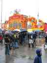 Oktoberfest crowds in the rain outside a beer/show "tent".