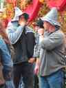 Revelers at Oktoberfest.  I have no proof, but these guys look like American college students to me.  I base the conclusion on the cheap souvenir hats, the general manner of dress, and the way they are smoking cigars as if it's not an accustomed thing.