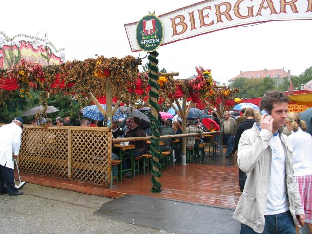 Rain never interferes with celebrations in Germany.  Here, revelers sit in an Oktoberfest Biergarten, umbrellas up, drinking away. Waiters with squeegees and towels would appear to dry off benches as needed.