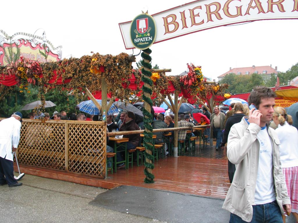 Rain never interferes with celebrations in Germany.  Here, revelers sit in an Oktoberfest Biergarten, umbrellas up, drinking away. Waiters with squeegees and towels would appear to dry off benches as needed.