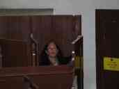 Pat inside one of the inmates' booths inside the prisoners' chapel at
Lincoln Castle.  Each of the booths has its own door, constructed so
that when someone is in the next booth, you can't get out.  The
corridor door locks.  The booths are designed so that you can't really
sit down, and the preacher can see whether everyone is paying
attention.  Pat and I briefly got locked in when one of the latches
jammed!  You'll note that in this shot, she is carefully holding the
door open so she doesn't get trapped again.