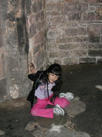 Xandie pretends to be a prisoner in one of the old towers at Lincoln
Castle.  These towers were unheated and without barriers on the
windows; being a prisoner must have been truly horrendous.  Photo by
Pat.