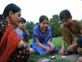 Xandie plays a card game with her friend Hurria (R, in brown) and her
sisters and cousins.