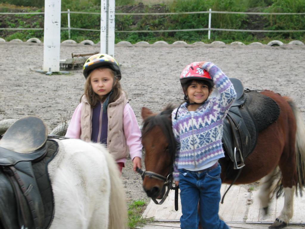 Xandie and her riding partner, Emma, lead Suse back to the stables
after their first lesson.  Yes, the pony really is that small.