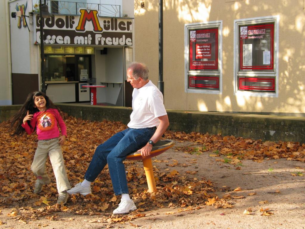 Xandie and Daddy play on the one-person merry-go-round in St. Wendel.