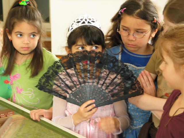 Xandie tries signaling with a fan during her birthday party at the Schlo.  L to R: Kathy, Xandie, Vivian, Fleur (obscured), Katherine.