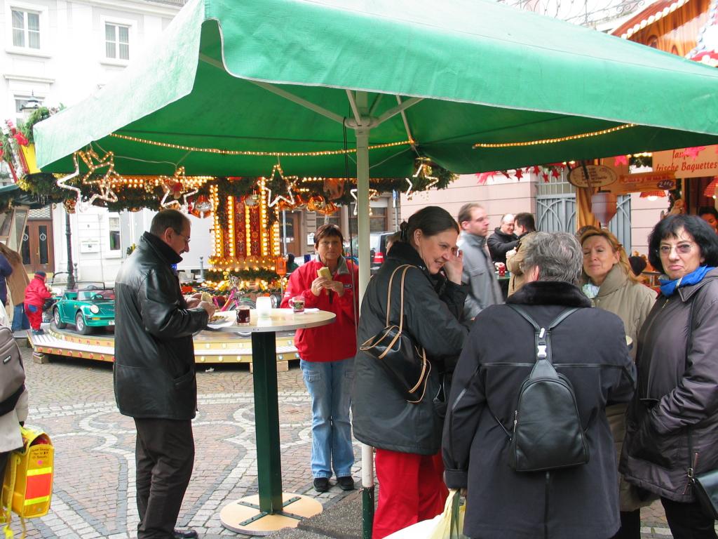Revelers grab a bite and a glass of Glhwein at the Karlsruhe Christmas market.