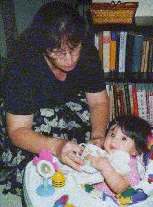 Mommy helps with a cup