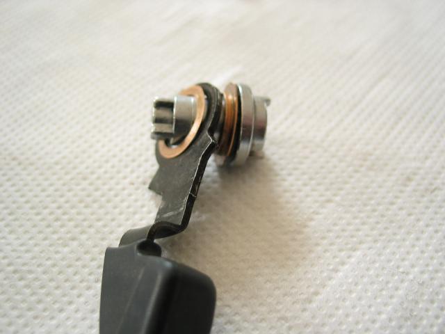 Correct assembly of the downshift lever.  The cam pivot has been
removed from the shifter for clarity.  The hat-shaped bushing goes
onto the pivot first, followed by the lever and the flat bushing.
Make sure you orient the lever as shown, with the first bend going
toward the shift cam.